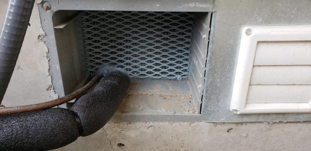 A foundation vent repaired to keep rats out of the home.